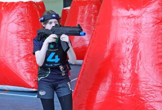 Игрок "Blue Team" с лазертаг-винтовкой у красного укрытия.